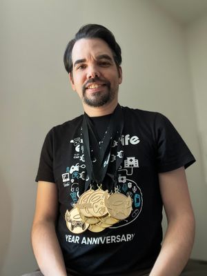 Mike sporting an Extra Life t-shirt and wearing nine gold medals around his neck.